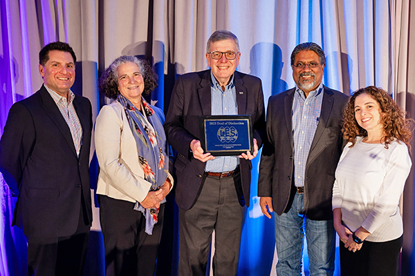 Steven Ferguson, NIH, shows off the award (center) with presenter Kannan Krishnaswami (right), along with Kannan’s LES IUGI co-chairs Adrian Cyhan (left), Corine Farewell and Jennifer Mandina.